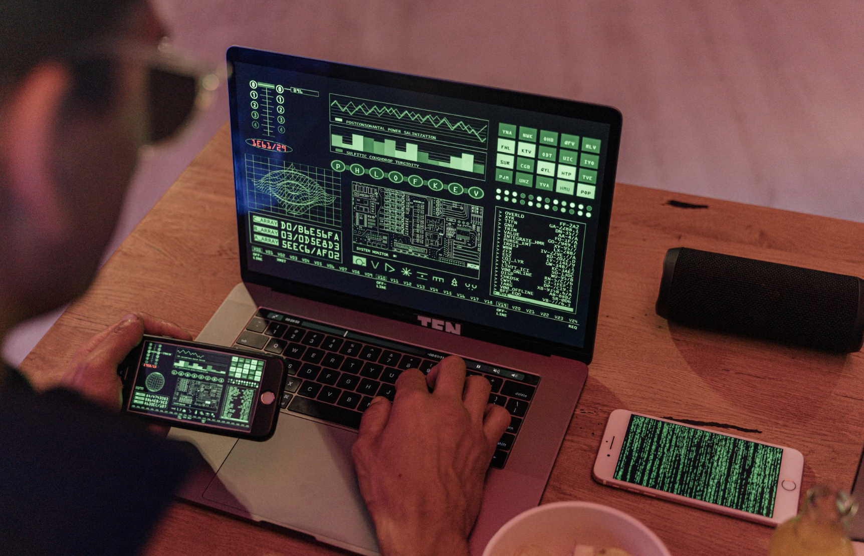 a forensic analyst working on their phone and laptop simultaneously